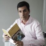 Autor com o livro nas mãos